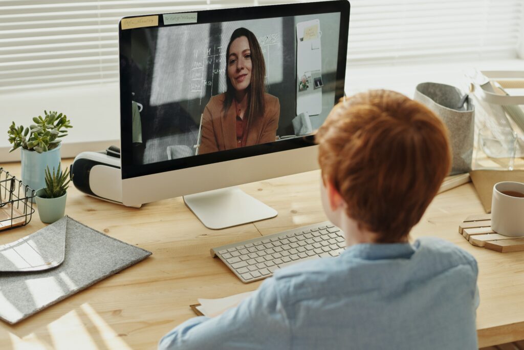 Young boy with his tutor during an online lesson