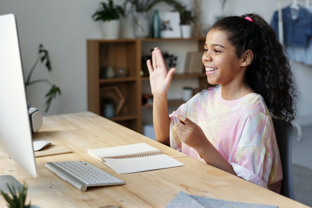 Little girl answering her lesson during an online class