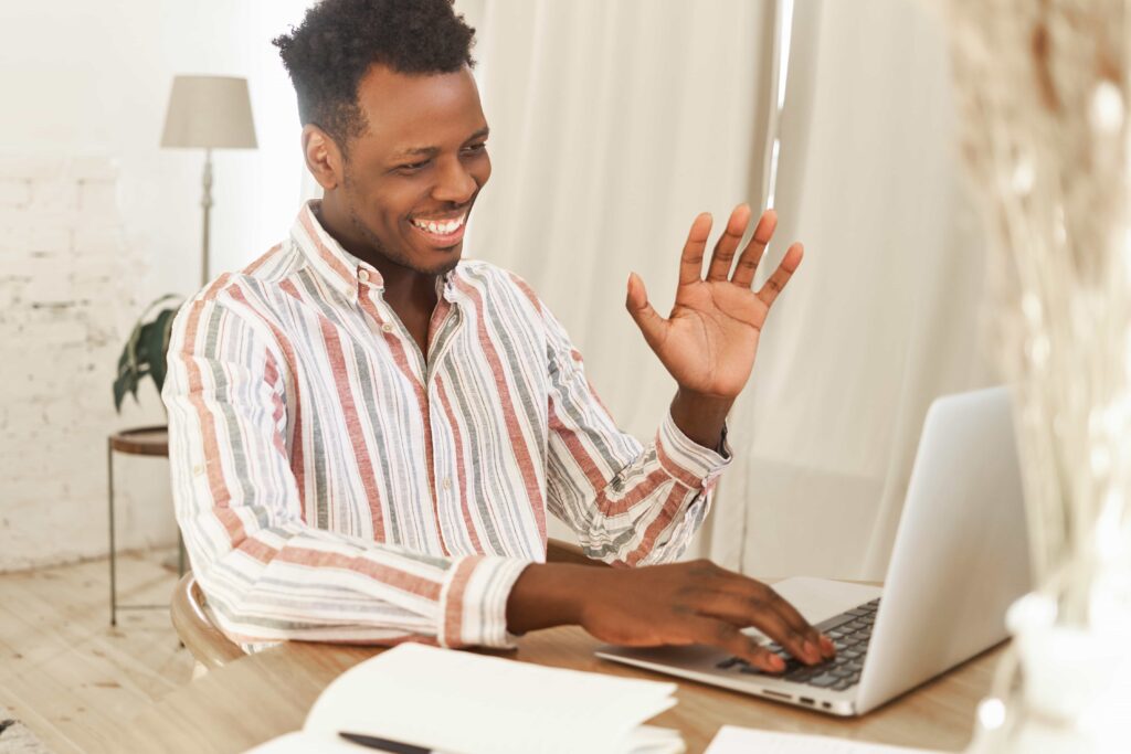 Tutor smiling and waving online lesson