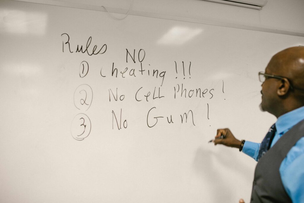 Teacher writing classroom rules on the whiteboard