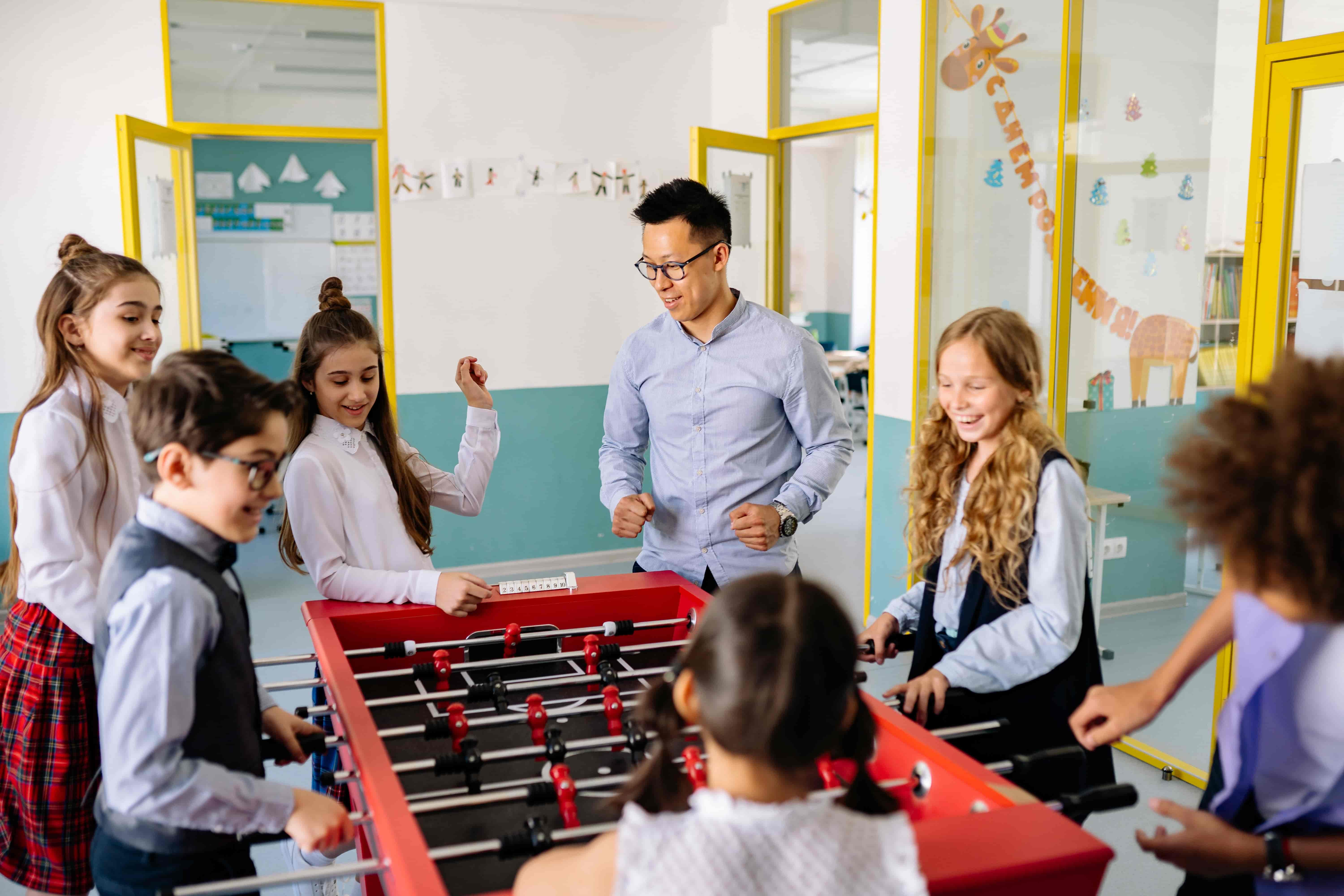 Teacher plays table football with students