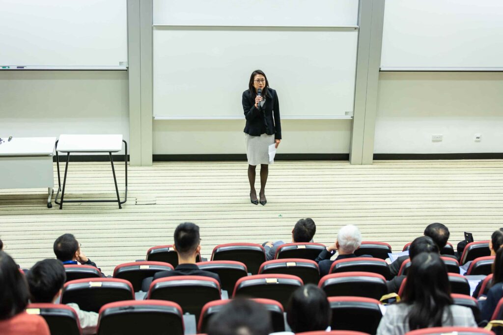 Woman reading a lecture for a large number of students