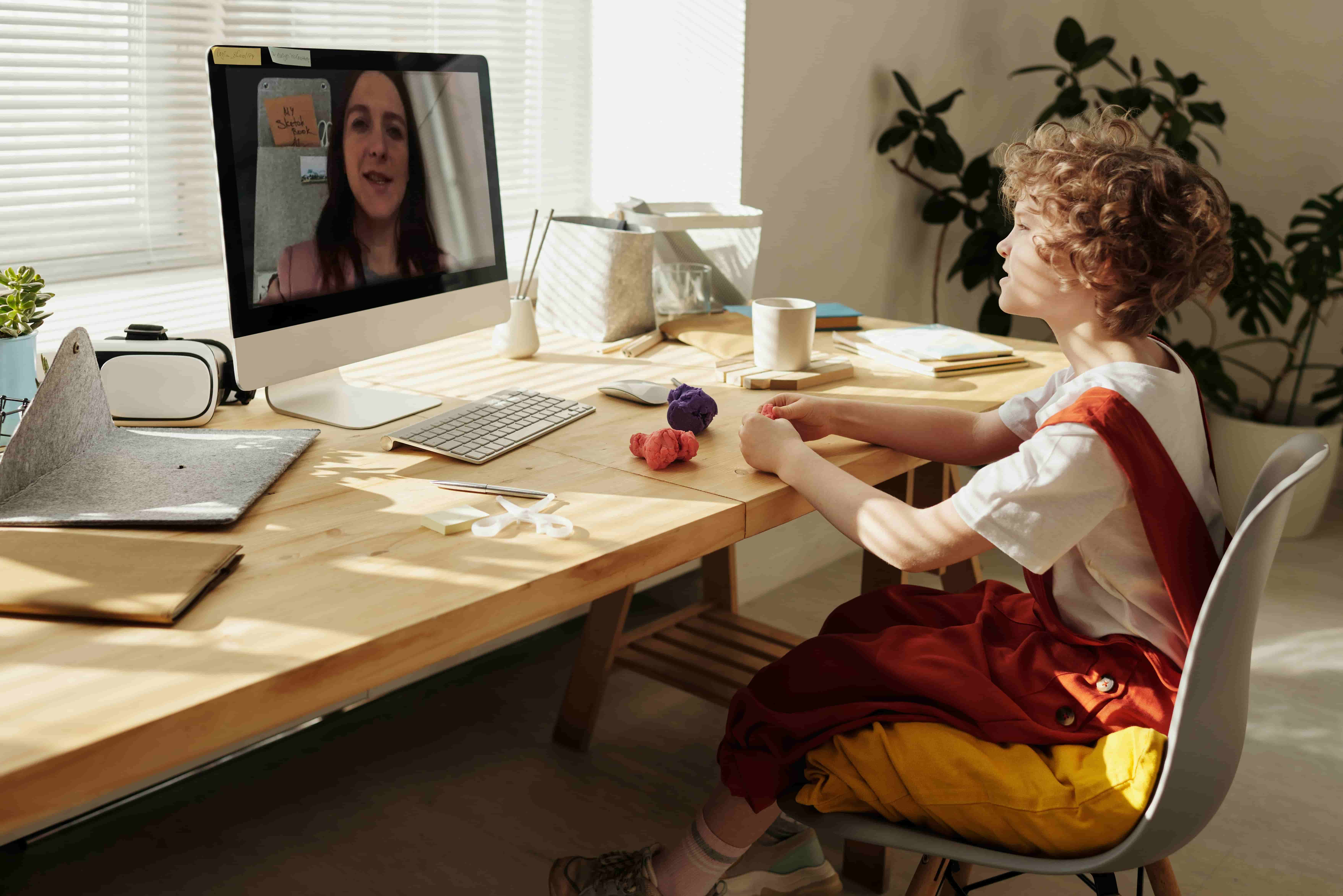 Little boy listening to his teacher at an online lesson